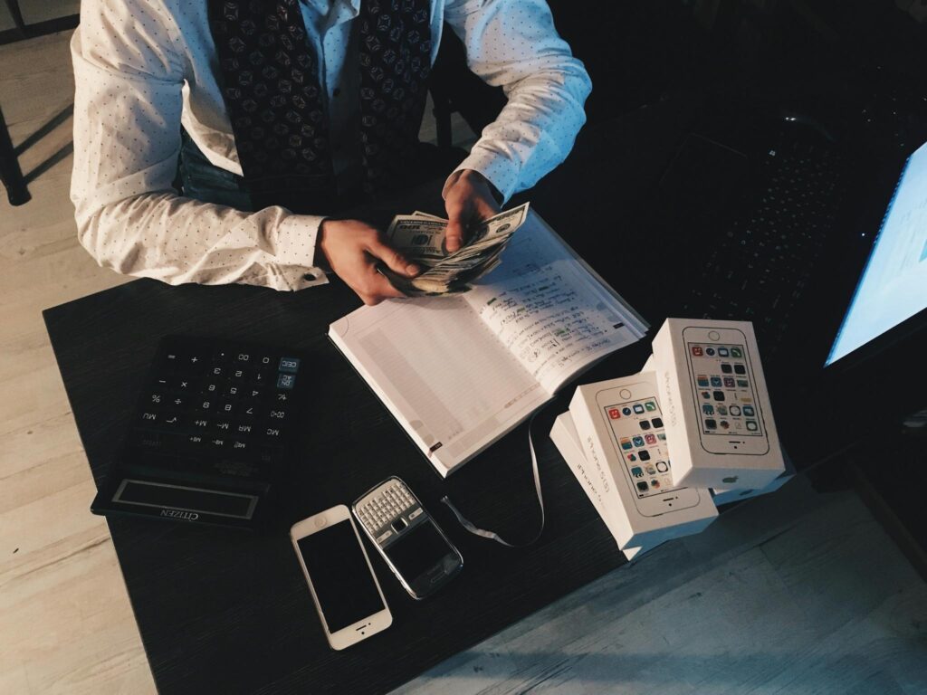 Never Run Out of Ideas: Top Tips for Generating Fresh Blog Topics Businessman organizing finances with tech devices and cash on desk.